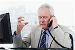 Irritated senior manager on the phone in his office