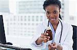 Young female doctor giving medication in her office