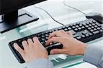 Masculine hands typing on a keyboard