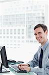 Side view of a happy office worker using a monitor in his office