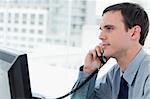 Young office worker on the phone`in his office