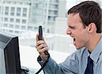 Angry office worker on the phone in his office