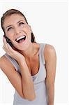 Portrait of a laughing woman making a phone call against a white background