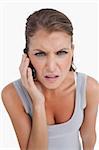 Portrait of a confused woman making a phone call against a white background