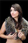 Sexy thoughtful brunette posing in fur. Isolated on black