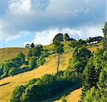 Summer mountain landscape with farmstead on hill top