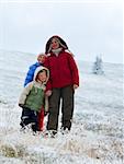 Family (mother with children) walk and play on autumn  mountain plateau with first winter snow