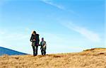 Family (mother with small son) walk on autumn  mountain plateau