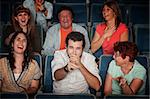Group of seven audience watching movie laugh in theater