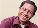 Portrait of happy mature Asian man smiling and looking at camera. Copy space