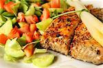 A picture of fresh salmon grilled with rosemary and served with salad and asparagus on side