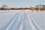 Next snowmobile on the frozen lake, sunset