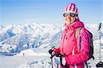 Young woman with skis and a ski outfit in the Zillertal Arena, Austria