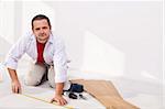 Man installing laminate flooring at home - the isolation layer