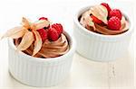 Two servings of chocolate mousse dessert with fruit