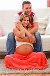 Family portrait of smiling pregnant woman with husband