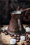 Old-fashioned oriental coffee pot on grunge wooden plank