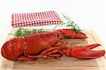 a lobster with dill on a wooden board