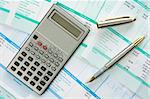 calculator,pen  and payroll summary details