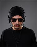 DJ listening to headphones on a dark background.