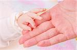 Close-up of baby's hand holding mother's hand