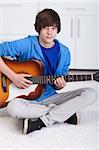 Young teenager boy playing the acoustic guitar