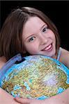 Young girl dreaming about a trip - holding a globe, closeup