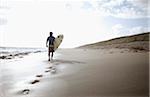 Surfeur marchant sur la plage