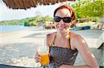 Femme avec mangue boire sur la plage, près de Paraty, Rio de Janeiro, Brésil