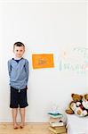 Boy with drawings on bedroom wall