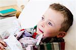 Boy with thermometer in mouth in bed