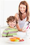 Mother pouring cereal for son