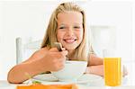 Girl eating cereal at breakfast table