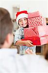 Junge in Nikolausmütze mit Weihnachtsgeschenke