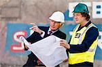 Workers reading blueprints on dry dock