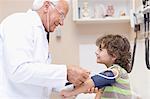 Doctor examining boy in office