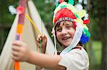 Boy with bow wearing Indian headdress