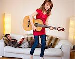 Girl playing guitar in living room
