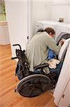 Man with spinal cord injury in a wheelchair doing his laundry at home