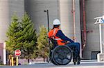 Ingénieur des installations dans un fauteuil roulant, étude des réservoirs de stockage en vrac en plein air