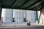 Facilities engineer in a wheelchair inspecting outdoor bulk storage tanks