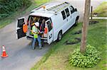 Communications worker preparing to climb pole at his truck