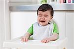 Baby boy in high chair, crying