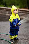 Boy holding garden hose