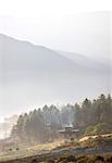 Vue tôt le matin dans la vallée de Gangtey rempli de brouillard vers traditionnels ruraux bhoutanais abrite près de Gangtey, Bhoutan, Himalaya, Asie