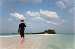 Woman with cell phone on a tropical beach, Kuramathi Island, Ari Atoll, Maldives, Indian Ocean, Asia