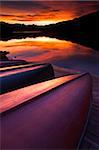 Lined up canoes reflect the colours of a stunning sunset, Canada, North America