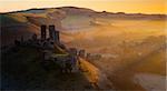 Misty winters sunrise over the village and castle at Corfe, Dorset, England, United Kingdom, Europe