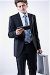 Young Businessman Looking at Digital Tablet and Carrying Briefcase