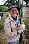 Portrait d'homme tenant des morceaux de bambou, Inutabu, île de Tokunoshima, préfecture de Kagoshima, Japon